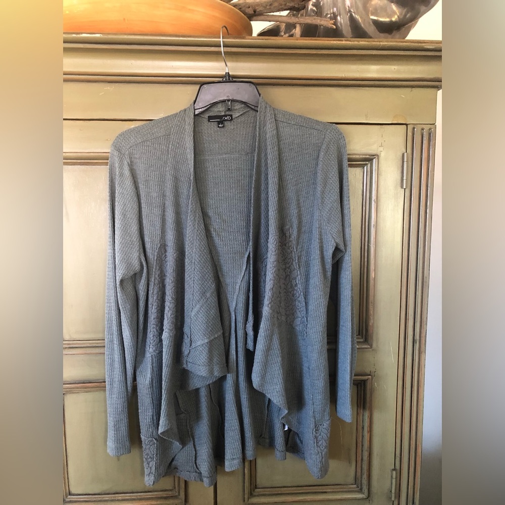 Woman’s pebble blue/gray swing sweater with lace detail.